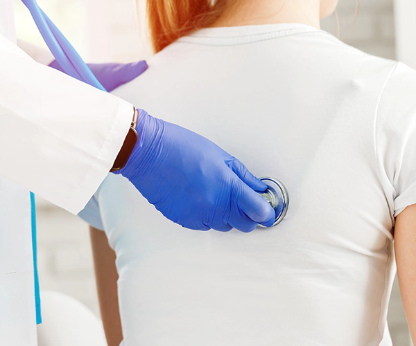 Arzt hört mit Stethoskop den Herzschlag einer Patientin ab